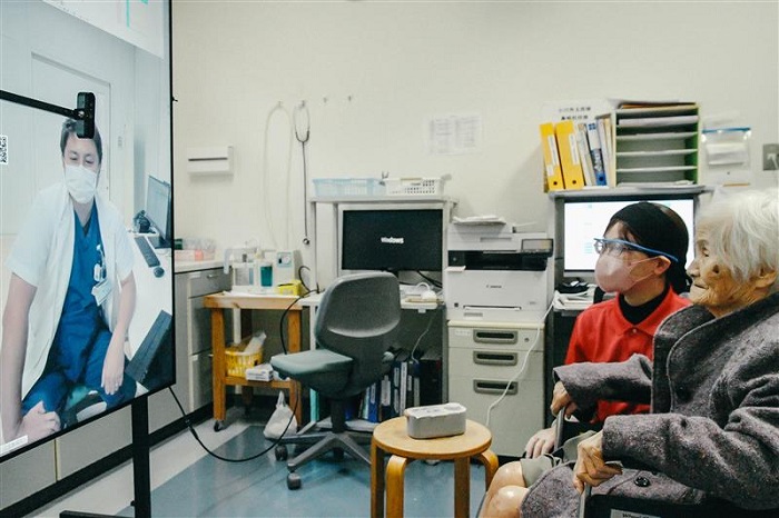 上五島病院と福見の園でのオンライン診療様子。「窓」で患者の身体のみならず周囲の環境も確認することができる。（提供：MUSVI）